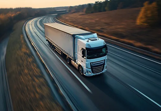 Lastbil på motorvej gennem åbent landskab